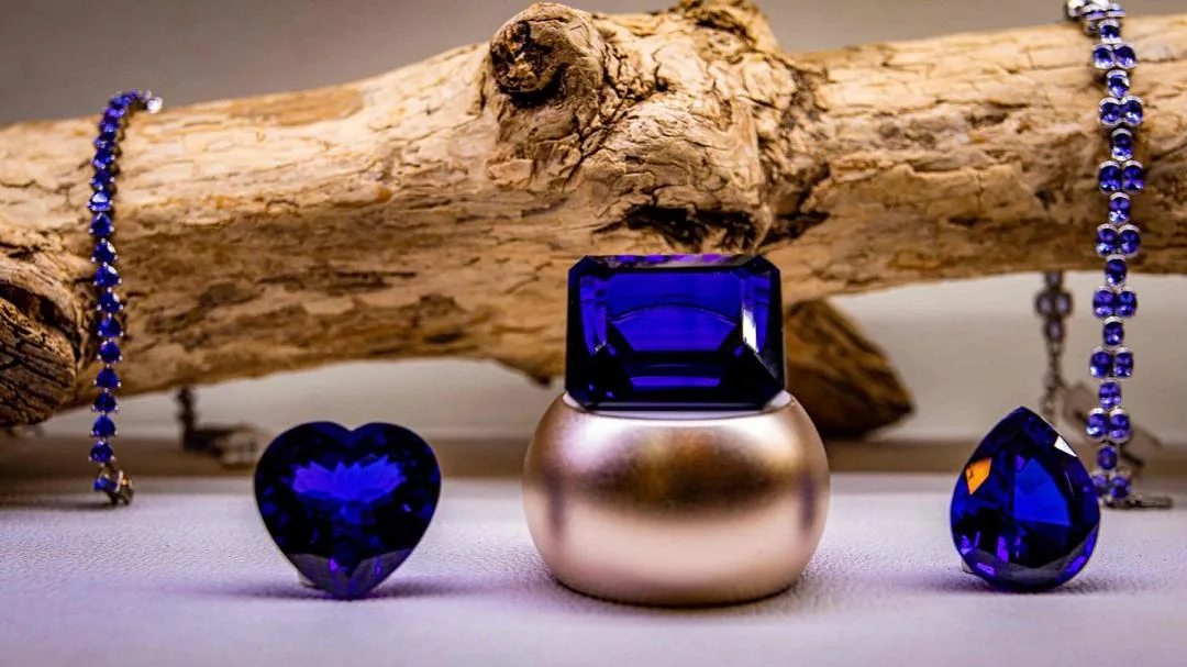 Polished tanzanite jewelry displayed on driftwood