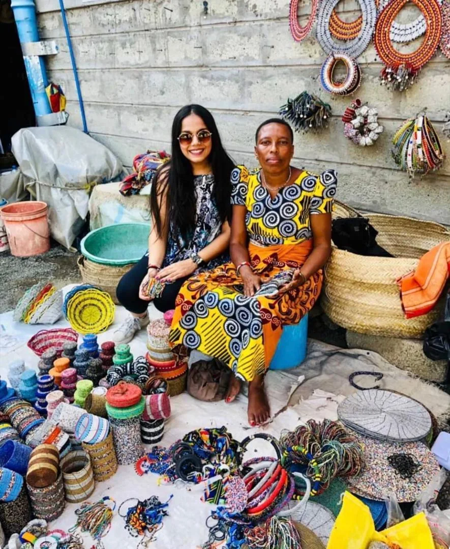 Guest with a market vendor surrounded by beadwork