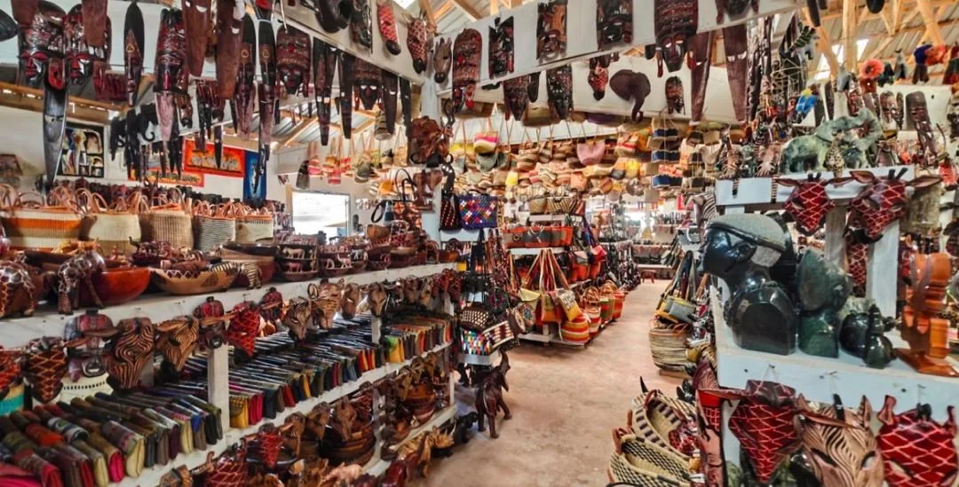 Indoor craft market packed with carvings, masks and bags